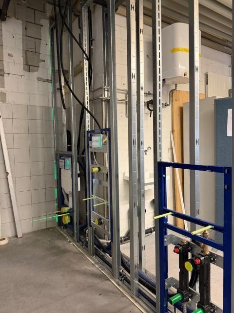 Blaue Vorwandelemente zwischen senkrechten Metallprofilen einer neuen Wand